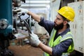 Man engineer wear yellow helmet holding tablet and uniform working at industrial workshop. handsome workman. Royalty Free Stock Photo