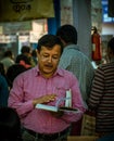 A man engrossed in reading a book at the Kolkata Book Fair