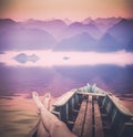 Man enjoy sunrise above the misty peaks. Instagram stylization