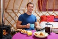 Man Enjoying Breakfast Whilst Camping In Traditional Yurt Royalty Free Stock Photo