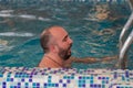 Man enjoying a leisurely swim in a snowcovered swimming pool Royalty Free Stock Photo