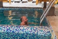 Man enjoying a leisurely swim in a snowcovered swimming pool Royalty Free Stock Photo