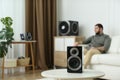 Man enjoying music with modern audio speaker system in room