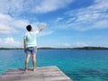 man enjoying sea landscape while standing on beach wooden pier with raised hand against sky background with copy space area for yo Royalty Free Stock Photo