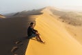 Man enjoying sunrise on top of huge sand dune. Sahara desert, Morocco. Royalty Free Stock Photo