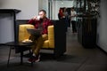 Man enjoying tasty fresh-brewed coffee sitting in armchair with laptop Royalty Free Stock Photo