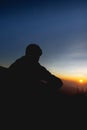 Man enjoying watching beautiful cloudscape sunrise on top of mountain cliff. Royalty Free Stock Photo