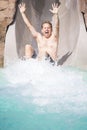 Man Enjoying a wet ride down Water Slide at a water park Royalty Free Stock Photo