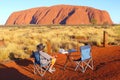 Man watching picnic sunset Uluru Ayers Rock, Australia