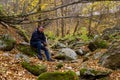 Man enjoys wildlife with stones in the autumn forest. Background with copy space. The concept of solitude with nature