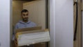 A man entering the apartment with a box. Media. An adult man entering a new apartment with large boxes. Royalty Free Stock Photo