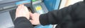 Man entering pin code at ATM and covering it with his hand closeup Royalty Free Stock Photo