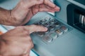 Man entering a PIN code for his credit card at an ATM, withdrawing money, finance concept Royalty Free Stock Photo