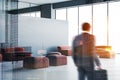 Man entering white office lounge area