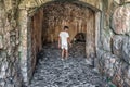 A man enters an ancient arched tunnel in Rozafa Castle, Albania Royalty Free Stock Photo