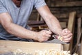 Man equals a wooden bar with a jack plane Royalty Free Stock Photo