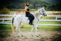Man equestrian on his horse riding at nature. Attractive man sitting on white horse on the ranch in autumn. Full length Royalty Free Stock Photo