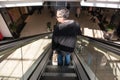 Man on escalator in shopping mall centre Royalty Free Stock Photo