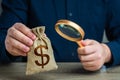 A man examines a dollar money bag through a magnifying glass. Royalty Free Stock Photo