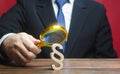 A man examines a paragraph figure with a magnifying glass. Studying laws and legislation, norms, rules. Legal service, lawyer