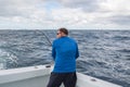 A man in excitement with a spinning in his hands pulls fish from the ocean from the side of the boat.. fishing in Florida. USA. Royalty Free Stock Photo