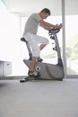 Man On Exercise Bike Pedaling At Home Royalty Free Stock Photo