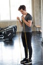 Man exercise elastic rubber band in gym