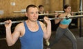 Man exercising with barbell during intense group workout