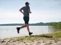 Active man exercising and stretching on the lake beac Royalty Free Stock Photo