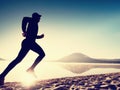 Man exercising on beach. Silhouette of active man exercising and stretching at lake Royalty Free Stock Photo