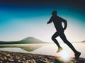 Man exercising on beach. Silhouette of active man exercising and stretching at lake Royalty Free Stock Photo