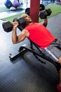 Man exercising with dumbbells on bench Royalty Free Stock Photo