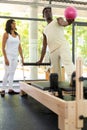 Man exercising pilates with female trainer in gym Royalty Free Stock Photo