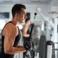 Man exercising in trainer for triceps muscles