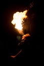 Man exhaling fire on a black background. Fire show