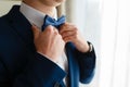 A man in an expensive suit straightens his tie.