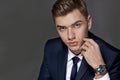 Portrait of a man sitting with a suit with a watch, studio