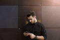 Handsome male confident office worker chatting on mobile phone, standing near company Royalty Free Stock Photo