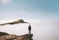 Man explorer standing alone on cliff edge mountain over clouds Royalty Free Stock Photo