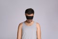 Man with eye mask in sleepwalking state on grey background