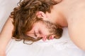 Man eyes are closed with relaxation. Lazy man happy waking up in the bed rising hands in the morning with fresh feeling Royalty Free Stock Photo