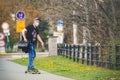 Man with a face mask respirator riding a longboard.