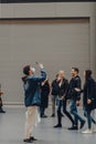 Man in a face mask taking photograph inside Turbine Hall of Tate Modern museum, London, UK