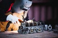 The man in the face mask is welded by argon welding. Welder industrial worker welding with argon machine Royalty Free Stock Photo