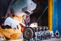 The man in the face mask is welded by argon welding. Welder industrial worker welding with argon machine Royalty Free Stock Photo