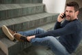 man fallen down staircase calling for help on smartphone Royalty Free Stock Photo