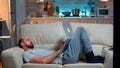 Man falling asleep in fron of TV while working on the laptop Royalty Free Stock Photo