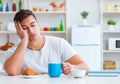 Man falling asleep during his breakfast after overtime work Royalty Free Stock Photo