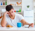 Man falling asleep during his breakfast after overtime work Royalty Free Stock Photo