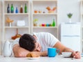 Man falling asleep during his breakfast after overtime work Royalty Free Stock Photo